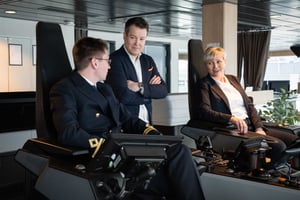 Hatteland Technology's Torhild Skrunes, and Andreas Rønning Stein from Norwegian Electric Systems, get a guided tour of Havila Polaris' bridge, by Eirik Bjerke, 2nd Officer Navigation at Havila Voyages. The image shows them sitting in / standing aside the pilot chairs of the vessel.