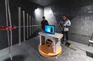 Two workers are testing a marine monitor in Hatteland Technology's EMC chamber.