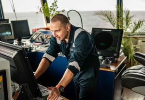 marine-navigational-officer-or-chief-mate-on-navigation-watch-operating a HATTELAND® Series 1 monitor. Another HATTELAND® Series 1 monitor can be seen in the background.
